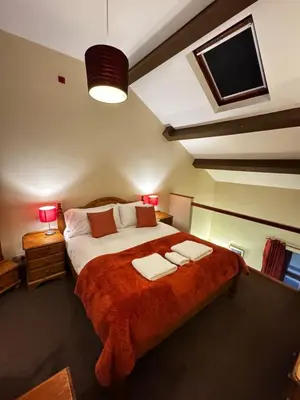 a bedroom with a large bed with two towels on it at The Wasdale Head Inn & Apartments in Seascale