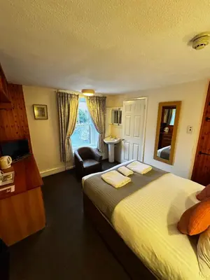 a hotel room with a large bed and a bathroom at The Wasdale Head Inn & Apartments in Seascale
