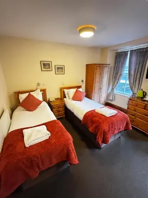 a bedroom with two beds with red blankets at The Wasdale Head Inn & Apartments in Seascale