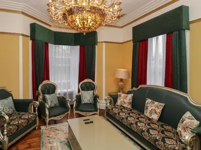 a living room with a couch and chairs and a chandelier at Beechgrove Manor in Workington
