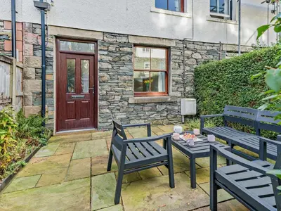 two benches and a table in front of a building at 2 Bed in Keswick 95741 in Keswick