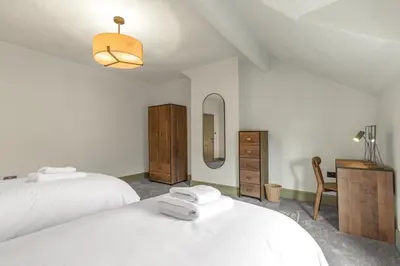a bedroom with two white beds and a mirror at Boutique Home in Lake District, West Cumbria in Workington