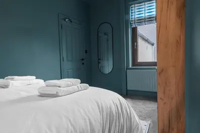 a blue bedroom with two beds with towels on them at Boutique Home in Lake District, West Cumbria in Workington