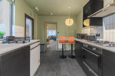 a kitchen with orange bar stools in a kitchen at Boutique Home in Lake District, West Cumbria in Workington