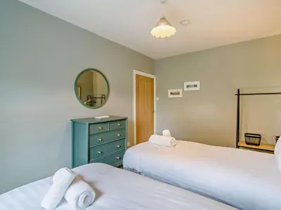 a bedroom with two beds and a mirror at 4 Bed in Keswick oc-95739 in Bassenthwaite