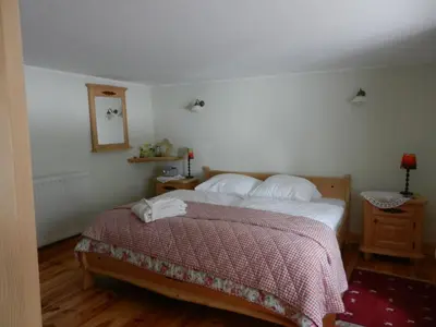 a bedroom with a bed with a red and white blanket at Armidale Cottages B&B in Workington