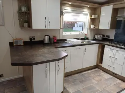 a kitchen with white cabinets and a counter top at Muirfield cosy retreat in Girvan