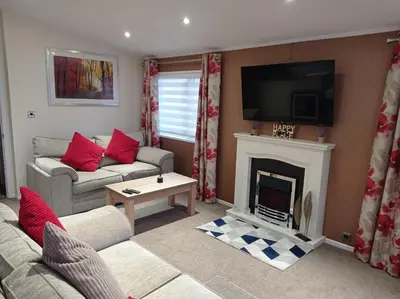 a living room with a couch and a fireplace at Muirfield cosy retreat in Girvan