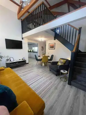 a living room with a couch and a staircase at Watchhall, Annan, Dumfries & Galloway, Scotland Barn - 2 Bed in Annan