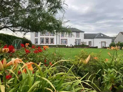 a large white house with flowers in front of it at Watchhall, Annan, Dumfries & Galloway, Scotland Barn - 2 Bed in Annan