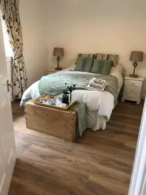 a bedroom with a bed with a tray of food on it at Station House Flat on outskirts of Thornhill in Thornhill