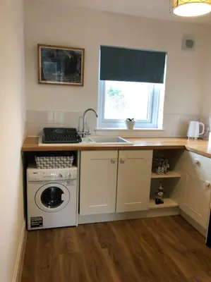 a kitchen with a sink and a washing machine at Station House Flat on outskirts of Thornhill in Thornhill
