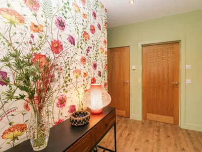 a room with a vase and flowers on a wall at Esk Brae in Langholm