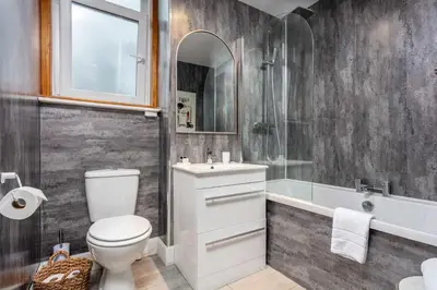 a bathroom with a toilet and a sink and a tub at The Bradshaw in Prestwick