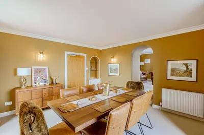a dining room with a wooden table and chairs at Balcary Tower in Castle Douglas
