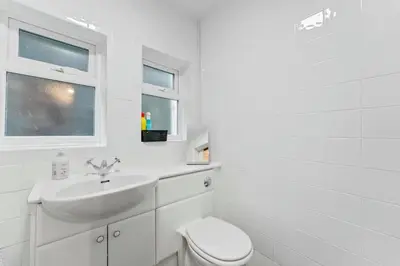 a white bathroom with a toilet and a sink at The Escape in Portinscale