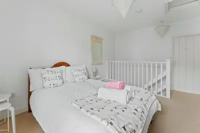 a white bedroom with a white bed with pillows at The Escape in Portinscale