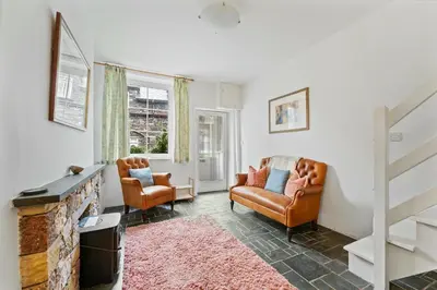 a living room with two chairs and a fireplace at The Escape in Portinscale