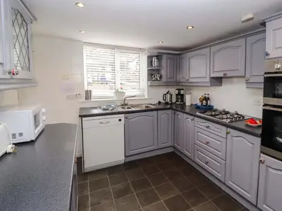 a kitchen with gray cabinets and white appliances at Brews Cottage in Keswick