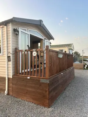a house with a wooden deck with a window at Ralfgus 16 Forest Views caravan Park,Moota in Plumbland