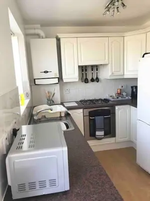 a kitchen with white cabinets and a white appliance at CosyHouse1 Private Parking Base for Lake District and Sellafield in Cleator