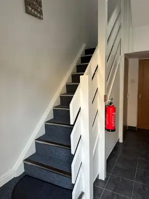 a stairway with a fire extinguisher in the middle at Spacious Property For Hols Base & Contractors Long or Short Stays C2C Western Lakes in Cleator Moor