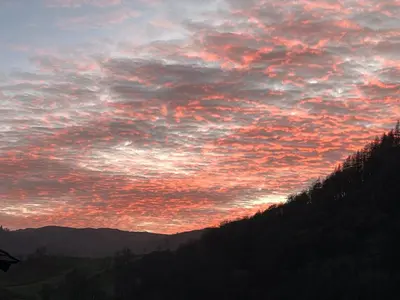 a sunset in the sky over a mountain at The Shepherd's Nook in Thirlmere