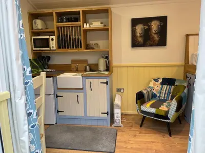 a kitchen with a couch and a chair in a room at The Shepherd's Nook in Thirlmere