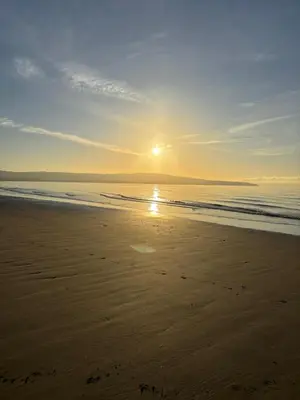 a sunset on a beach with the ocean at No 10, Ayr, 130m2, New Decor December 2024, All new entire 3 bedroom garden house in Ayr