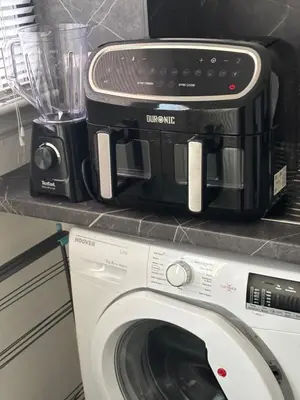 a black microwave sitting on top of a washing machine at No 10, Ayr, 130m2, New Decor December 2024, All new entire 3 bedroom garden house in Ayr