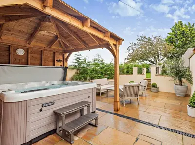 a hot tub on a patio with a wooden gazebo at 2 Bed in Cockermouth 95716 in Broughton Moor