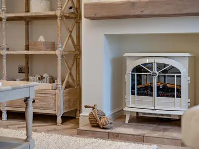 a living room with a fireplace and a table at 2 Bed in Cockermouth 95716 in Broughton Moor
