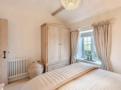 a bedroom with a bed and a cabinet and a window at 2 Bed in Cockermouth 95716 in Broughton Moor