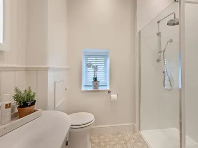 a white bathroom with a toilet and a shower at 2 Bed in Cockermouth 95716 in Broughton Moor