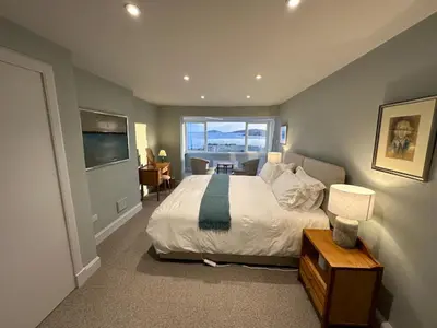 a bedroom with a large bed and a large window at Whitegates in Rockcliffe