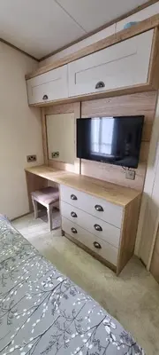 a bedroom with a dresser with a flat screen tv at Ramblers Retreat in Cockermouth