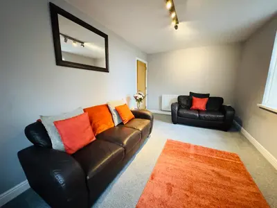 a living room with a leather couch and two chairs at New Road Apartment - 2 Bedrooms - Sleeps 3 in Whitehaven