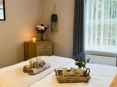 a bed with a basket of towels and candles on it at New Road Apartment - 2 Bedrooms - Sleeps 3 in Whitehaven