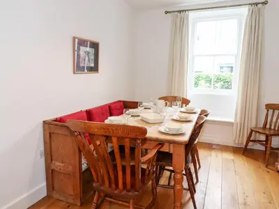 a dining room table with chairs and a red couch at Middletown in Keswick