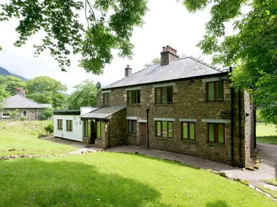an old brick house with a green yard at YHA Ennerdale in Buttermere