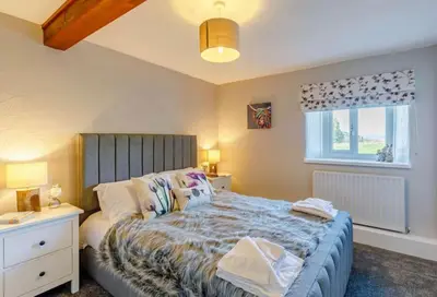 a bedroom with a large bed and a window at Troutbeck Inn Cottages in Troutbeck