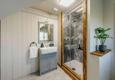 a bathroom with a sink and a shower with a mirror at Troutbeck Inn Cottages in Troutbeck