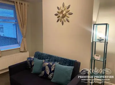 a living room with a couch and a flower clock on the wall at Jackson St by Prestige Properties SA in Siddick
