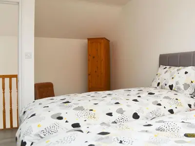 a bedroom with a bed with a comforter on it at Sunset View-E4107A in Aspatria