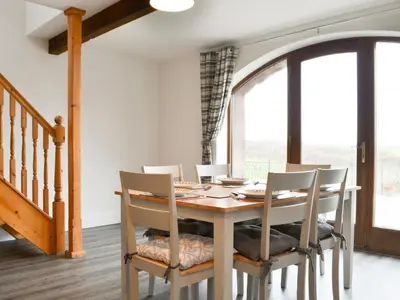 a dining room with a wooden table and chairs at Sunset View-E4107A in Aspatria