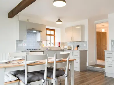 a kitchen with a wooden table and chairs at Sunset View-E4107A in Aspatria