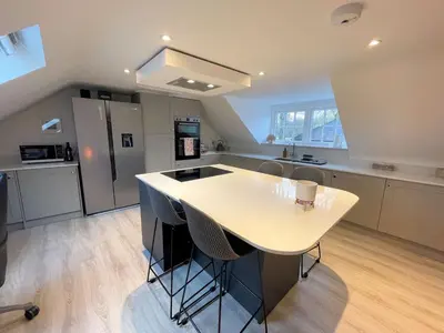a kitchen with a white island in the middle at Stunning Cosy Cottage in Historic Moffat - Pass the Keys in Moffat