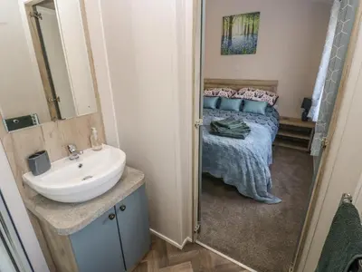 a bathroom with a sink and a bed at Brocklebank Lodge, 35 in Carlisle