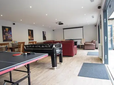 a room with a ping pong table and a projection screen at Family and dog friendly stunning barn conversion in Tarbolton