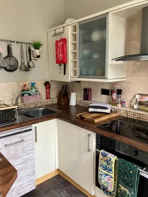 a kitchen with white cabinets and a sink at Apartment 28 in Ayr